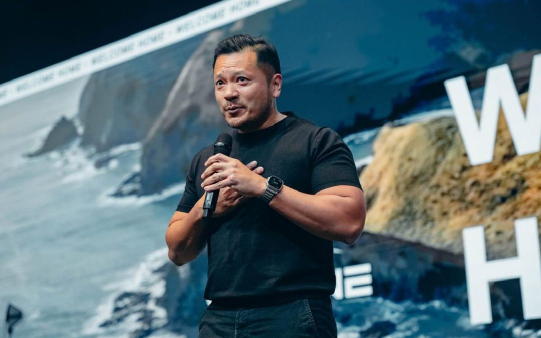 Man in black shirt, holding a microphone