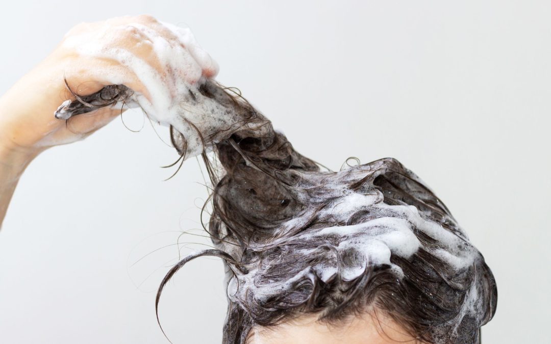 Long black hair getting shampooed with foam all over it